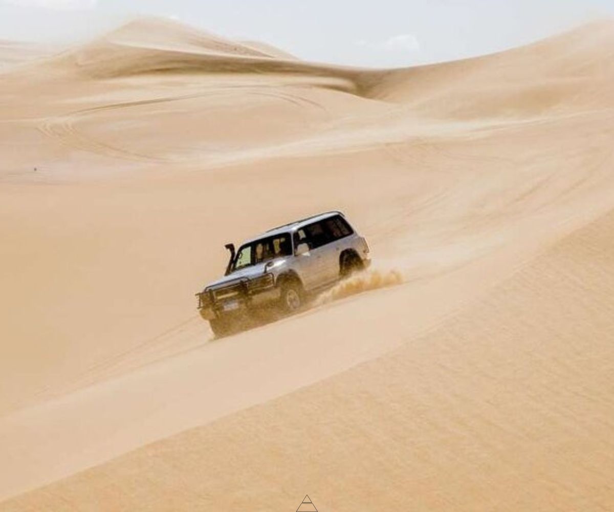 4x4 vehicle driving over sand dunes in El-Faiyum